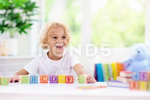 Child learning letters. Kid with wooden abc blocks Stock Photos