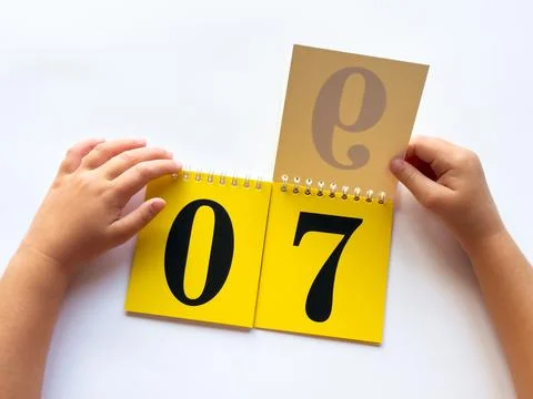 Child learning numbers with interactive flip calendar on white surface Foto stock