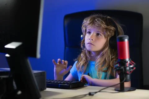 Child learning online at night, using desktop computer in living room at home. Stock Photos