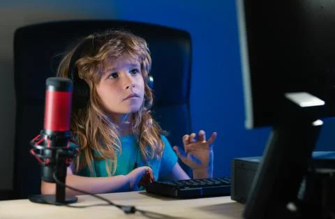 Child learning online at night, using desktop computer in living room at home. Stock Photos