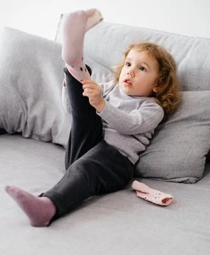 Child learning to put on socks Stock Photos