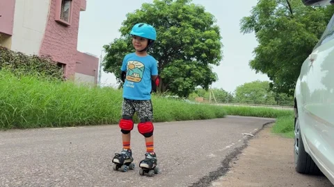 Child Learning Roller Skating Wearing Helmet Knee Pads and Protective Gear Vídeo Stock 347127904