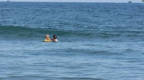 Child learning to surfboard the waves on bodyboard with farther,enjoying sea Stock Footage 55883114