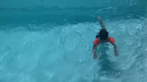 Child learning to swim with arm bands Stock Footage 305867415