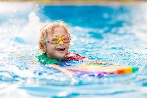 Child learning to swim. Kids in swimming pool. Stock Photos