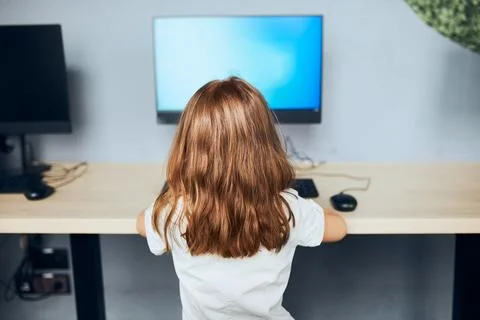 Child learning to use technology in classroom at primary school. Schoolgirl.. Foto stock