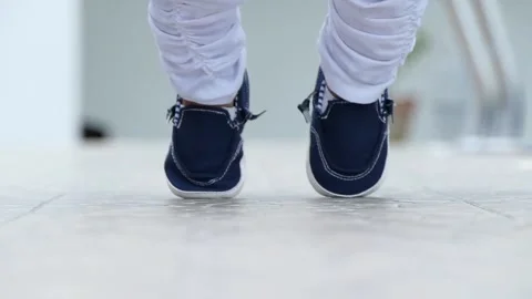 Child learning to walk for the first time in blue shoe Stock Footage 136289473