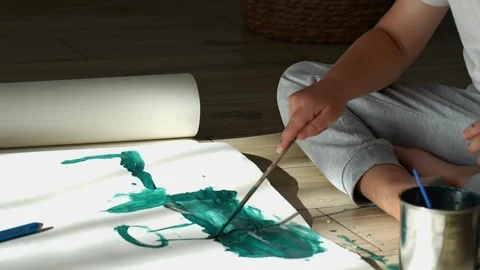 Child learning to work with colors, drawing with green paint on paper Stock Footage 286760649