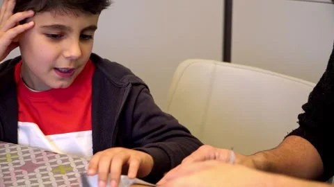 Child learning to wrap Christmas presents with his father Stock Footage 345253308