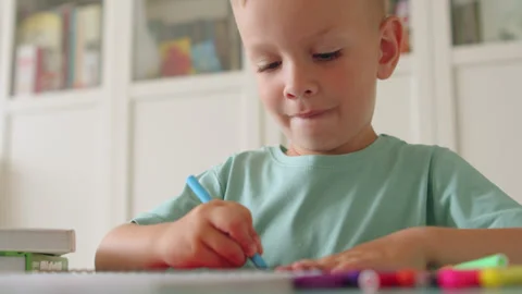 Child learning to write in a kindergarten. Cute little boy sitting at a des.. Stock Footage 336181885