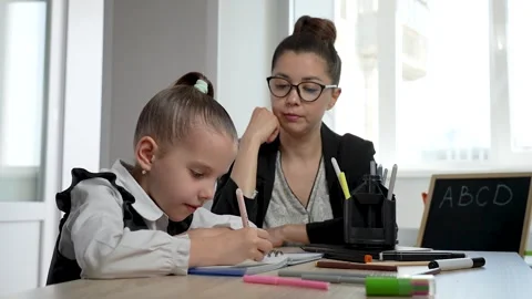 Child learning to write. Young school teacher helping cute little girl writ.. Stock Footage 273567665