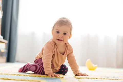The child learns to crawl on the floor. Stock Photos