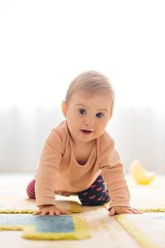 The child learns to crawl on the floor. Stock Photos