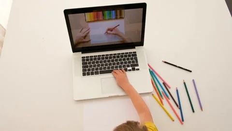 Child learns to draw from a tutorial on a laptop Vídeos de archivo 135315454