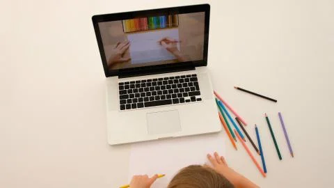 Child learns to draw from a tutorial on a laptop Stock Photos