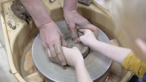 The child learns to make a vase of clay on a potter's wheel Stock Footage 121580576