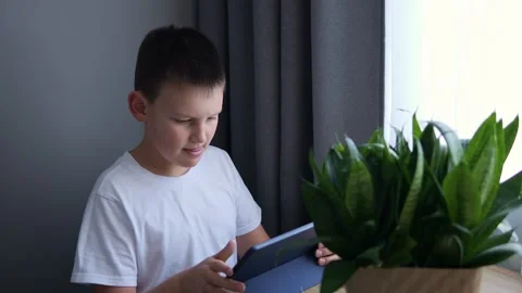 Child learns online with tablet embracing technology in education He utilize Stock Footage 266073439