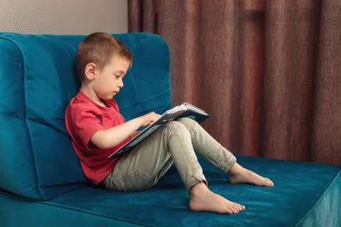 A child learns to read a book, the first fairy tale Stock Photos