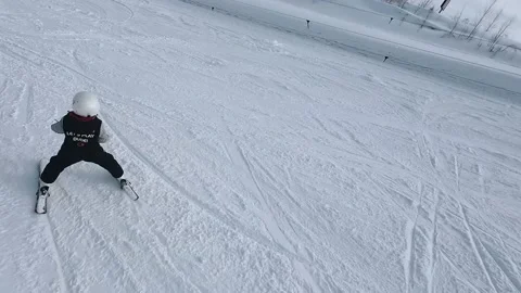 A child learns to ski with an instructor, fpv shooting Stock Footage 235421300