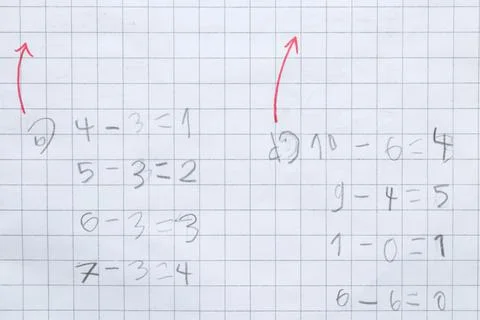 A child learns to solve simple math problems in a gridded notebook. Teachin.. Stock-Fotos