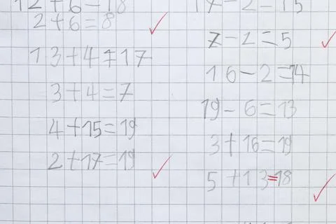 A child learns to solve simple math problems in a gridded notebook. Teachin.. Stock-Fotos
