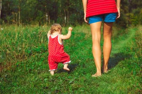 The child learns to walk on the grass 库存照片