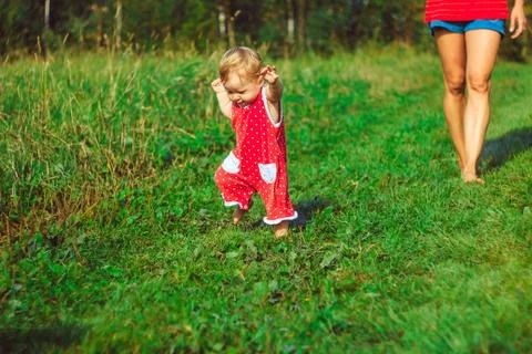 The child learns to walk on the grass Stock Photos