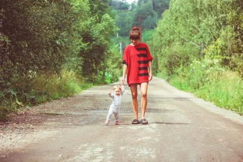 The child learns to walk on the grass 库存照片