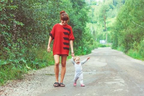 The child learns to walk on the grass 库存照片
