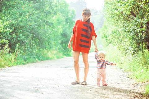 The child learns to walk on the grass 库存照片
