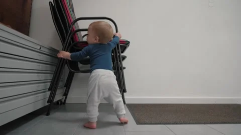 Child learns to walk by holding onto objects Stock Footage 336994368