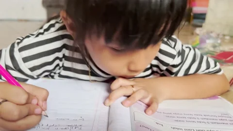 A child learns to write and do schoolwork Stock Footage 214341155