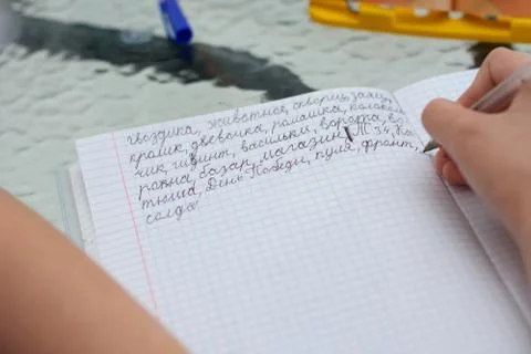 The child learns to write letters correctly and writes various words in Russi Stock Photos