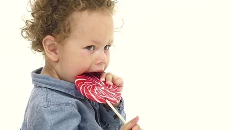 Child licks a candy. White background. Slow motion. Close up Stock Footage 76751251