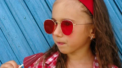 The child licks the red triangular lollipop Stock Footage 171137275