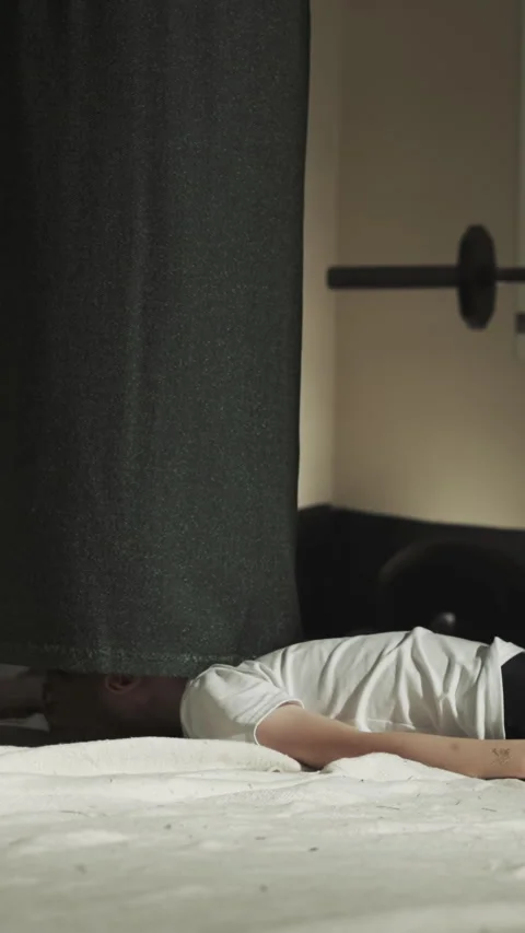 Child lies under staggering punching bag in gym Stock Footage 317399472