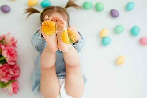 A child lies on a white background with Easter colored eggs Stock Photos