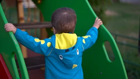 Child/ little boy in blue jacket and grey pants playing on the Playground Stock Footage 112080123