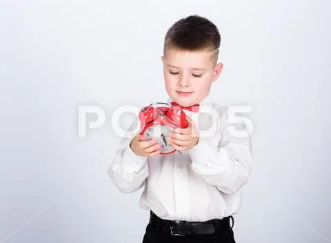 Child little boy hold red clock. It is time. Schedule and timing. Morning Stock Photos
