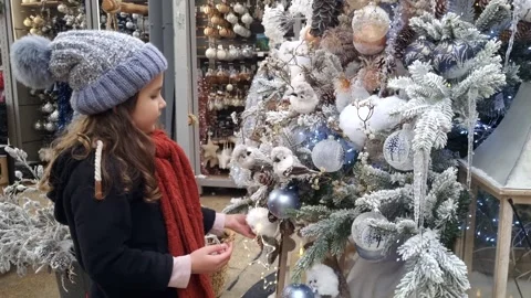 Child looking and touching a beautiful Christmas tree decorated with white Stock Footage 257417820