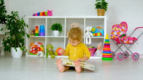 The child is looking at a book in the room. Selective focus. Stock Footage 208914213