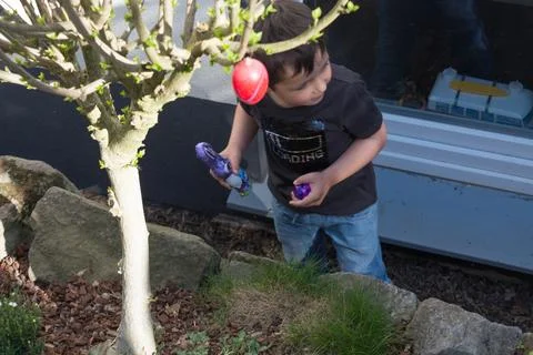 A child looking for Easter egg in the garden Stock Photos
