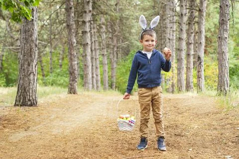 A child looking for Easter eggs in the forest. Little boy hunting for Easter  Stock Photos