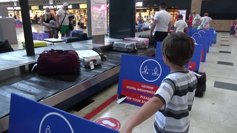 Child is looking out for his baggage on arrival in airport Stock Footage 140336948