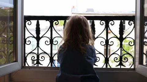 Child looking out the window. Stock Footage 252853472