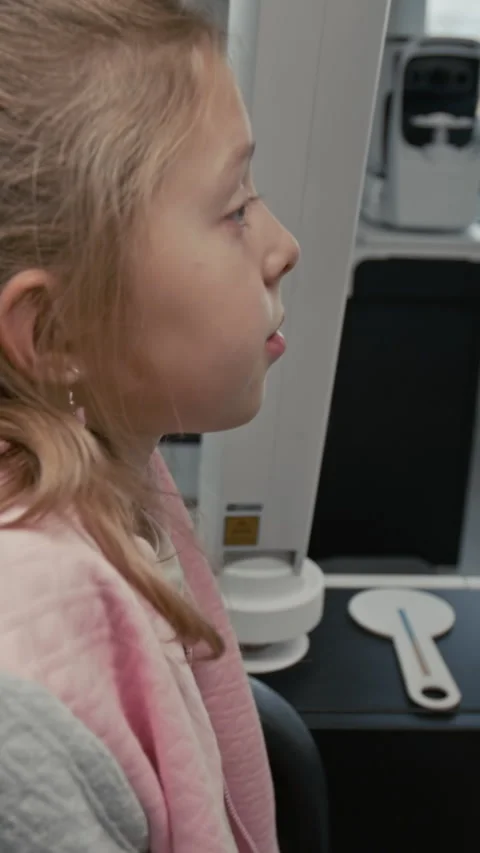 Child Looking into Phoropter During Eye Examination Vertical Stock Footage 322781917