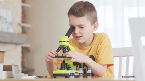 Child looking at something through a microscope, home study concept Stock Footage 170136264
