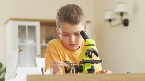 Child looking at something through a microscope, home study concept Stock Footage 170430149