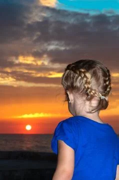Child looking at sunset Foto stock