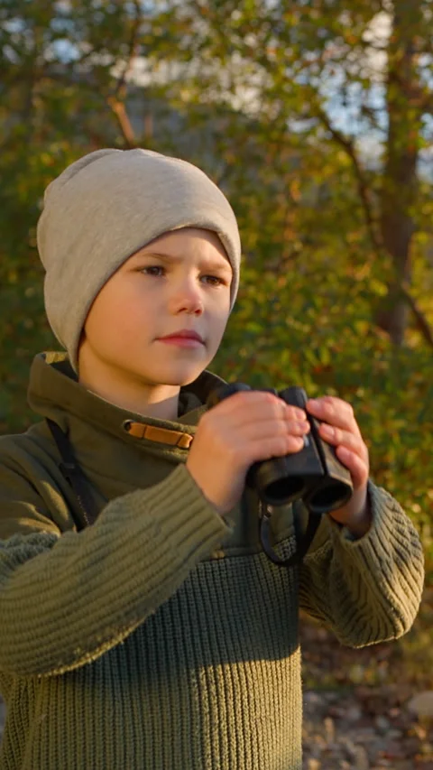 Child looking through binoculars in nature Stock Footage 314563155
